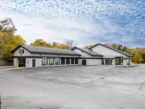 Large white building with car wash tunnel and two oil change bays.